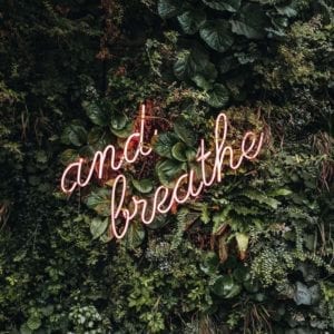 The words "and breathe" on a green leafy background