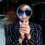 A curious woman looking through a magnifying glass