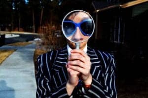 A curious woman looking through a magnifying glass