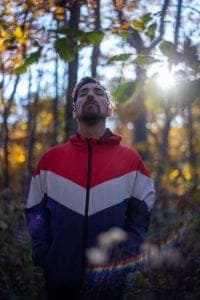 Man standing in woods breathing deep breaths becasue he has received a difficult diagnosis