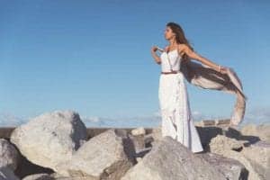 Woman dances freely on grey granite rocks