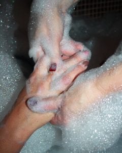 hands making soapy suds while washing