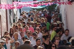 A crowd of people filing a street in celebration