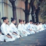 white clad people kneeling in meditation