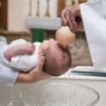 Ritual of priest baptizing a baby