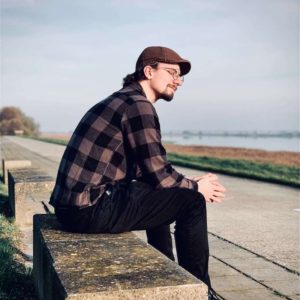 man sitting in bench by the ocean