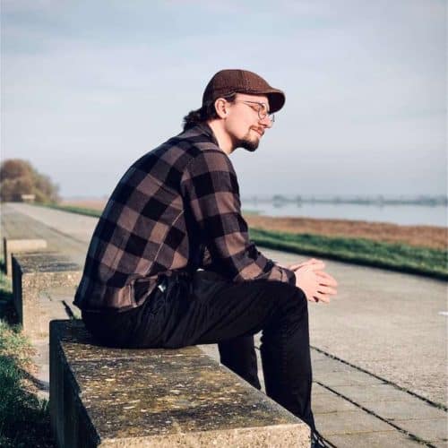 man sitting in bench by the ocean struggles with how to pray for your enemies