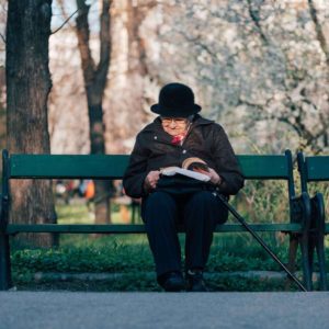 elderly lady on a bench reading