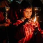 boy in lighting candle in religious rite