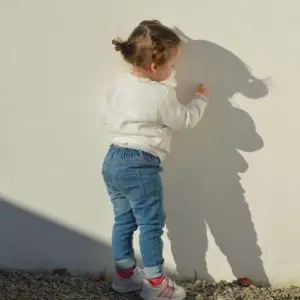 A small child writes on a wall