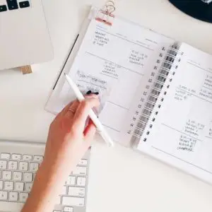 hand resting on open planner