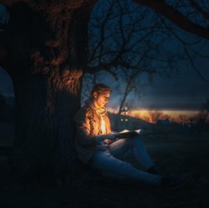 reading beside a campfire