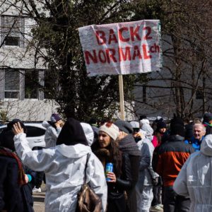 people holding sign that reads 'back to normal'