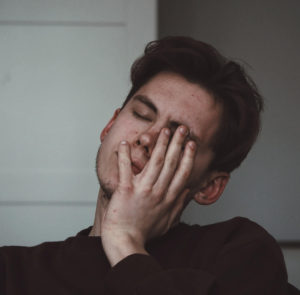 man in grief holding face with his hand Ardis Mayo