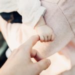 baby's hand grasping mom's finger