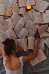 woman face down on a lot of open books