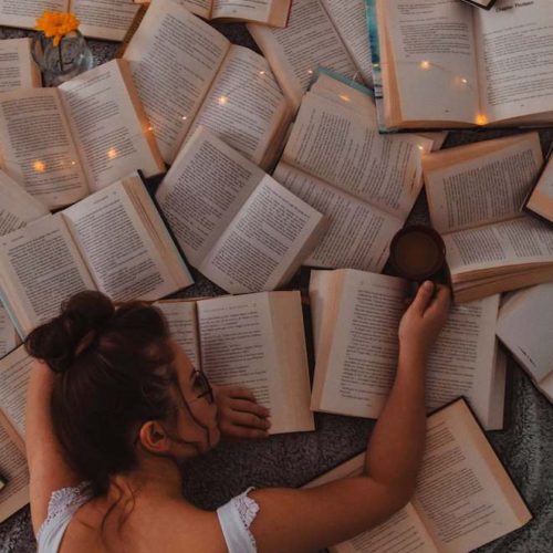 woman face down on a lot of open books; consumption vs digestion