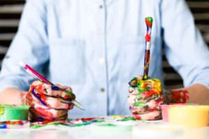 mans hands covered in paint while being creative