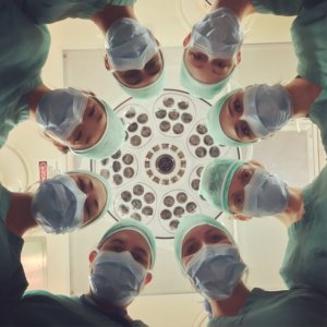 looking up in the masked faces of eight surgeons in a circle