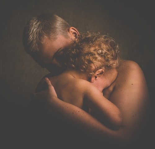 strong man holding weak child with feelings of grief