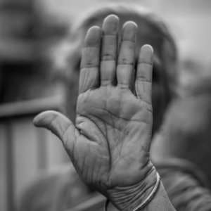 old lady with agency lifting her hand to say stop