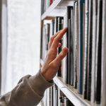 man's arm reaching for a library book