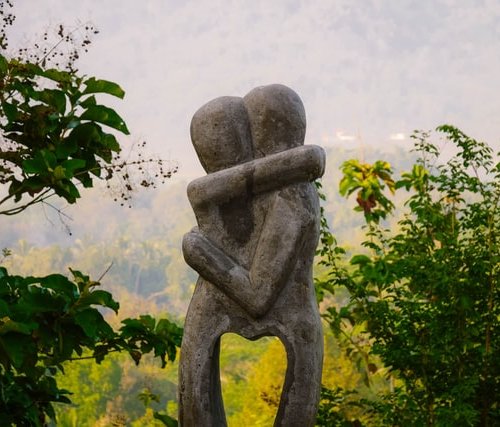 embracing stone statue to depict practicing for death...or joy in difficult times