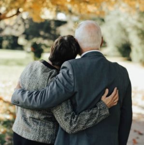 Couple standing at cemetery saying goodbye