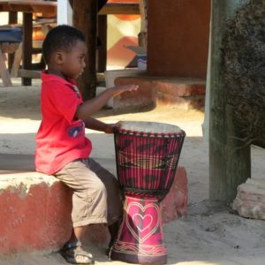 child playing djembe drum