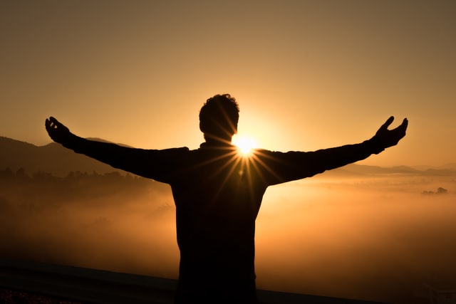 man who knows how to live fully lifts his arms to the sunset