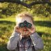 boy looks through binoculars to find god,Ardis Mayo