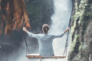 woman on a high swing over a steep gorge experiences the feeling of vulnerability