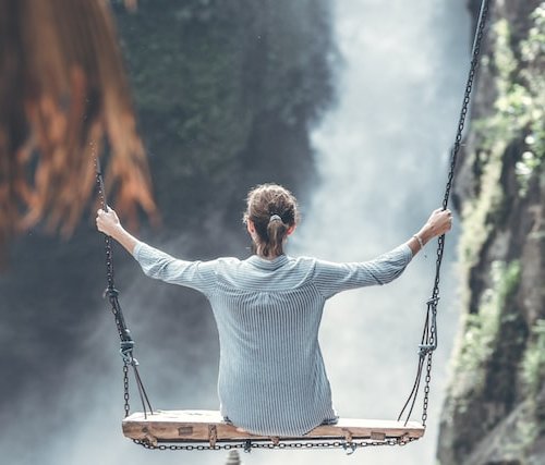 woman on a high swing over a steep gorge experiences the feeling of vulnerability...explore or persist